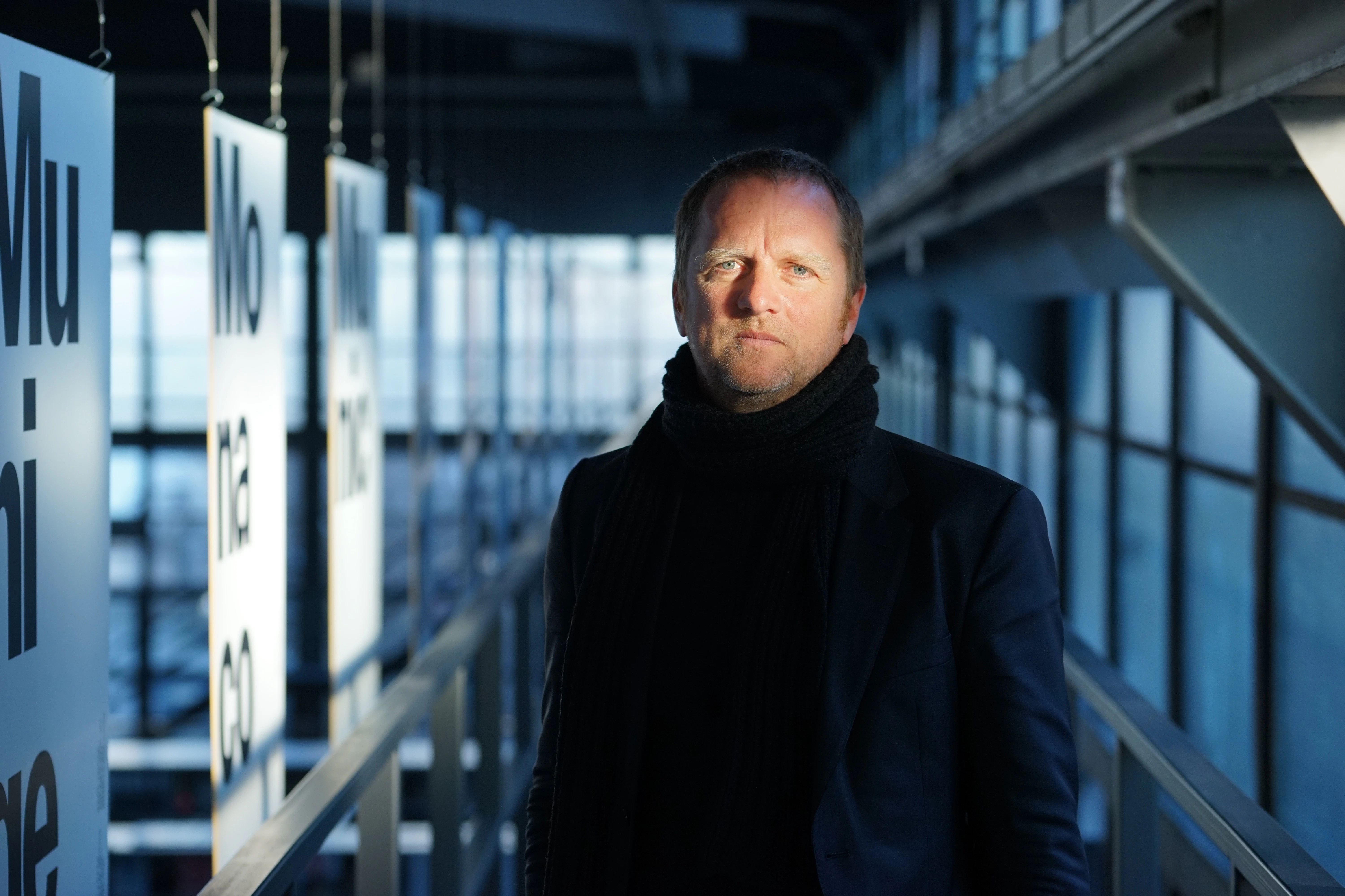 Owner and partner of Blackspace GmbH Michael Keller standing in the Blackhouse made out of windows and billboards